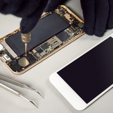 Technician or engineer disassembling components broken smartphone for repair or replace new part on desk