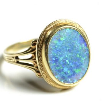 Opal and yellow gold ring.  On a white background.